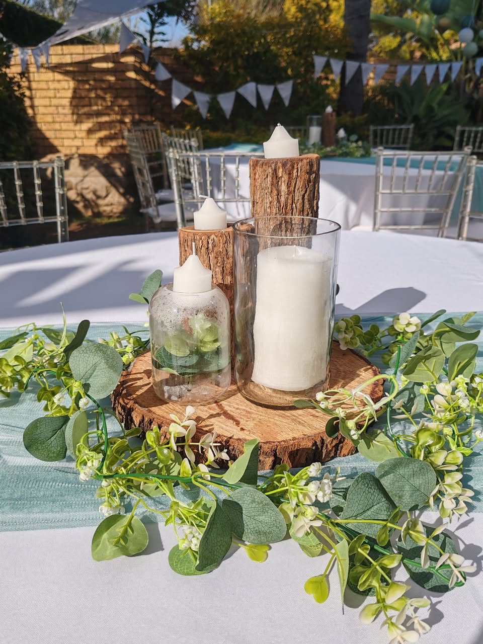 Candle and greenery centrepiece on a round table