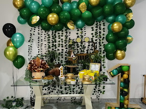 Green and gold balloon wall with greenery