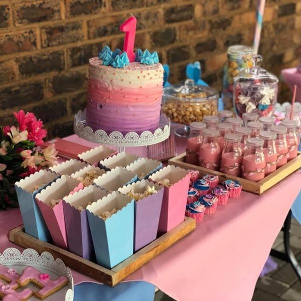 Pink first birthday cake with popcorn boxes