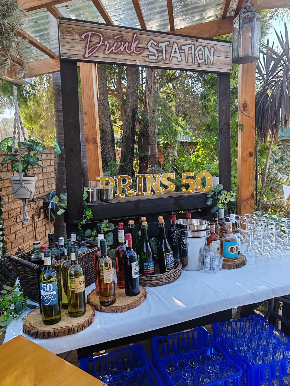 Rustic bar station with drinks and a 50th birthday sign