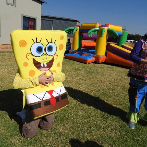 SpongeBob mascot at a kids party with a jumping castle